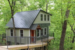 a tiny house on a deck in the woods at Secluded Treehouse in the Woods - Tree Hugger Hideaway in Branson