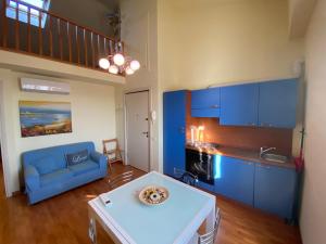 uma sala de estar com armários azuis e um sofá azul em Casetta, 54 em Sirolo