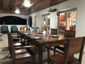 Deux-Palmes-Kribi, proche de la plage, confortable et adapté aux familles في كريبي: غرفة طعام مع طاولة وكراسي خشبية طويلة