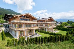 a house in the mountains with a yard at Tennerhof Luxury Chalets in Kitzbühel