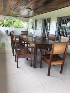 einen Esstisch mit Stühlen und einem Holztisch in der Unterkunft Deux-Palmes-Kribi, proche de la plage, confortable et adapté aux familles in Kribi