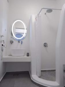 a white bathroom with a sink and a mirror at Shape-Infinity in Kalymnos