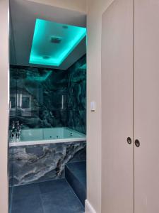 La salle de bains est pourvue d'une baignoire et d'un mur en pierre. dans l'établissement NOX Kensington Gardens, à Londres