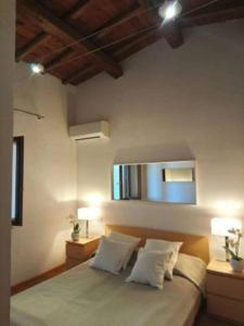 a bedroom with a bed with two lamps and a mirror at Villa Linnazello - elegant pool villa with sea view near Rome/Tuscany in Tarquinia +27 photos