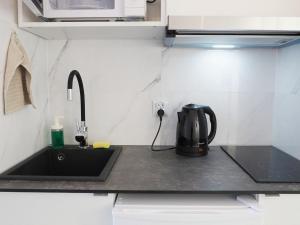 a kitchen counter with a tea kettle on a sink at OstWestApart A31 in Warsaw