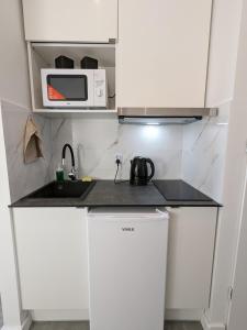 a small kitchen with a sink and a microwave at OstWestApart A31 in Warsaw