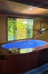 a large blue tub in a room with a window at Mizu Spa & Hospedagem in Alter do Chao