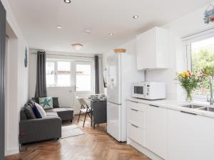een keuken en een woonkamer met een bank en een magnetron bij The Cove in Holyhead