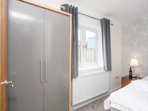 een spiegel in een slaapkamer met een bed en een raam bij The Cove in Holyhead