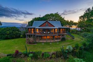 una casa grande en un campo de hierba en Mountain Retreat with ocean views, en Kin Kin