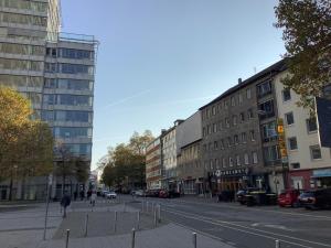 een persoon die door een straat met gebouwen loopt bij City Apartments Essen in Essen