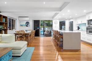 a kitchen and living room with a table and chairs at Luxury holiday house Pool WIFI Airconditioning in Alexandra Headland