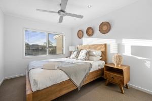 Habitación blanca con cama y ventana en Luxury holiday house Pool WIFI Airconditioning, en Alexandra Headland