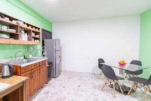 a kitchen with a sink and a table with chairs at Casa Marina: Habitación Monterrey in Acámbaro