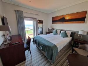 a hotel room with a bed and a desk and a window at Sea Lodge Hotel in Waterville