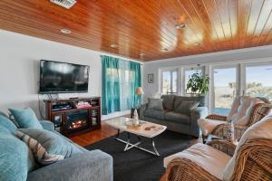 un salon avec deux canapés et une télévision dans l'établissement Sea Glass Cottage - An Oceanfront Experience, à Saint Augustine