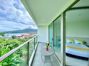 una camera da letto con un letto e un tavolo sul balcone di Oceana Sea View - Kamala Beach a Kamala Beach