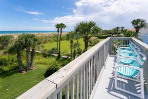 - une rangée de chaises sur un balcon donnant sur l'océan dans l'établissement Sea Glass Cottage - An Oceanfront Experience, à Saint Augustine