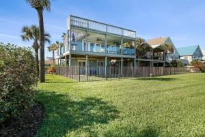 une grande maison avec une clôture devant une cour dans l'établissement Sea Glass Cottage - An Oceanfront Experience, à Saint Augustine