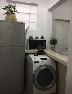 a kitchen with a washing machine and a microwave at Acogedora y confortable habitación cerca del WTC in Mexico City