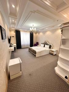 a large bedroom with a bed and a television at Suleyman hotel in Bukhara