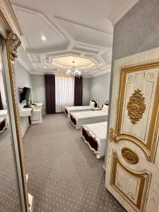 a hotel room with two beds and a mirror at Suleyman hotel in Bukhara