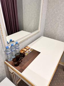 a table with two bottles of water and a mirror at Suleyman hotel in Bukhara
