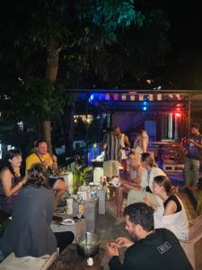 un grupo de personas sentadas alrededor de un patio por la noche en Rock View Hostel Ella, en Ella