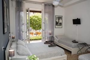 Duas camas num quarto branco com uma janela em B&B Pisaland em Pisa