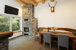 a dining room with a wooden table and a fireplace at Alpine Cottage Golica in Jesenice