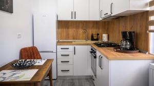 a kitchen with white cabinets and a wooden counter top at Nina House in Târgu Jiu