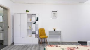 a bedroom with a yellow chair and a desk at Natura Residence in Târgu Jiu