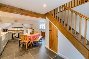 a kitchen and dining room with a staircase and a table at The Hayloft in Tiverton