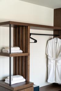a wooden shelf with towels and a robe at Athens Design Suites in Athens