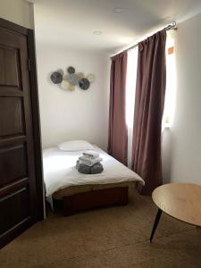 een kleine slaapkamer met een bed en een raam bij GORGANY resort & SPA in Yablunytsia