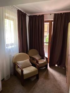 uma sala de estar com duas cadeiras e uma janela em GORGANY resort & SPA em Yablunytsya