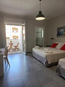 um quarto com 2 camas, uma mesa e um pátio em ViaRiva Rooms em Cagliari