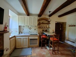 eine Küche mit weißen Schränken und einem Tisch mit Stühlen in der Unterkunft La Casa di Agnese in Spello