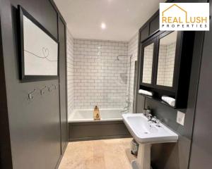 a bathroom with a sink and a bath tub at Real Lush Properties - Spacious Four-Bedroom House, Ideal for Families & Contractors , Burton in Burton upon Trent