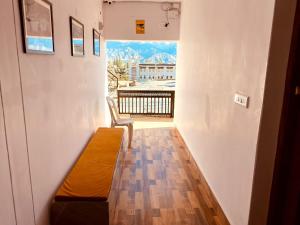 a room with a bench and a balcony with a view at Milam Hostel in Leh +14 photos