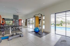 a fitness room with a gym with a swimming pool at Luxurious sandton apartment with Inverter in Sandton