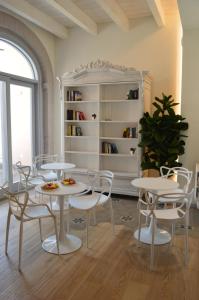 uma sala com mesas e cadeiras e uma estante de livros em TANIT ROOMS & SPA em Villasimius