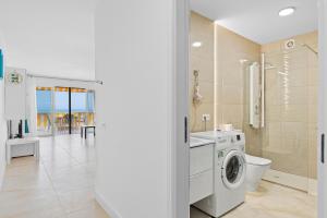 a bathroom with a washing machine and a toilet at Neptuno Ocean View, Beach line with Pool in Puerto de Santiago
