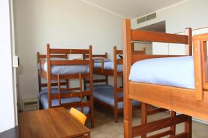 a room with bunk beds and a table and chairs at Student's Hostel Parma in Parma