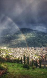un arco iris sobre una ciudad con una ciudad en '' Al Pèrgul '', en Civo
