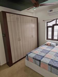 a bedroom with a bed and cabinets and a window at Treva Pent House in Tirunallār