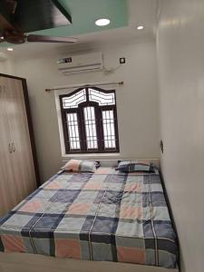 a bedroom with a bed in a room with a window at Treva Pent House in Tirunallār