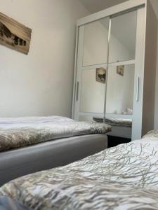 een slaapkamer met 2 bedden en een spiegel bij mooihusen in Norden