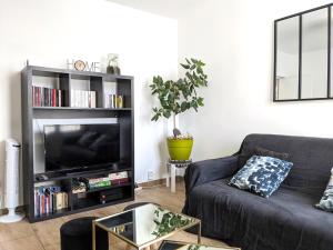 - un salon avec un canapé et une télévision dans l'établissement Grande maison rénovée au calme aux portes de Paris, à Romainville
