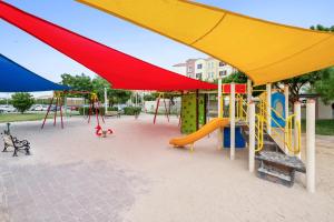 a playground with colorful play equipment in a park at Luxury studio in Discovery Gardens near metro in Dubai